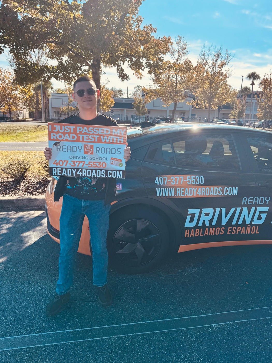 Driving school student in front of Ready 4 Roads dual-control car in Kissimmee, FL after DMV road test